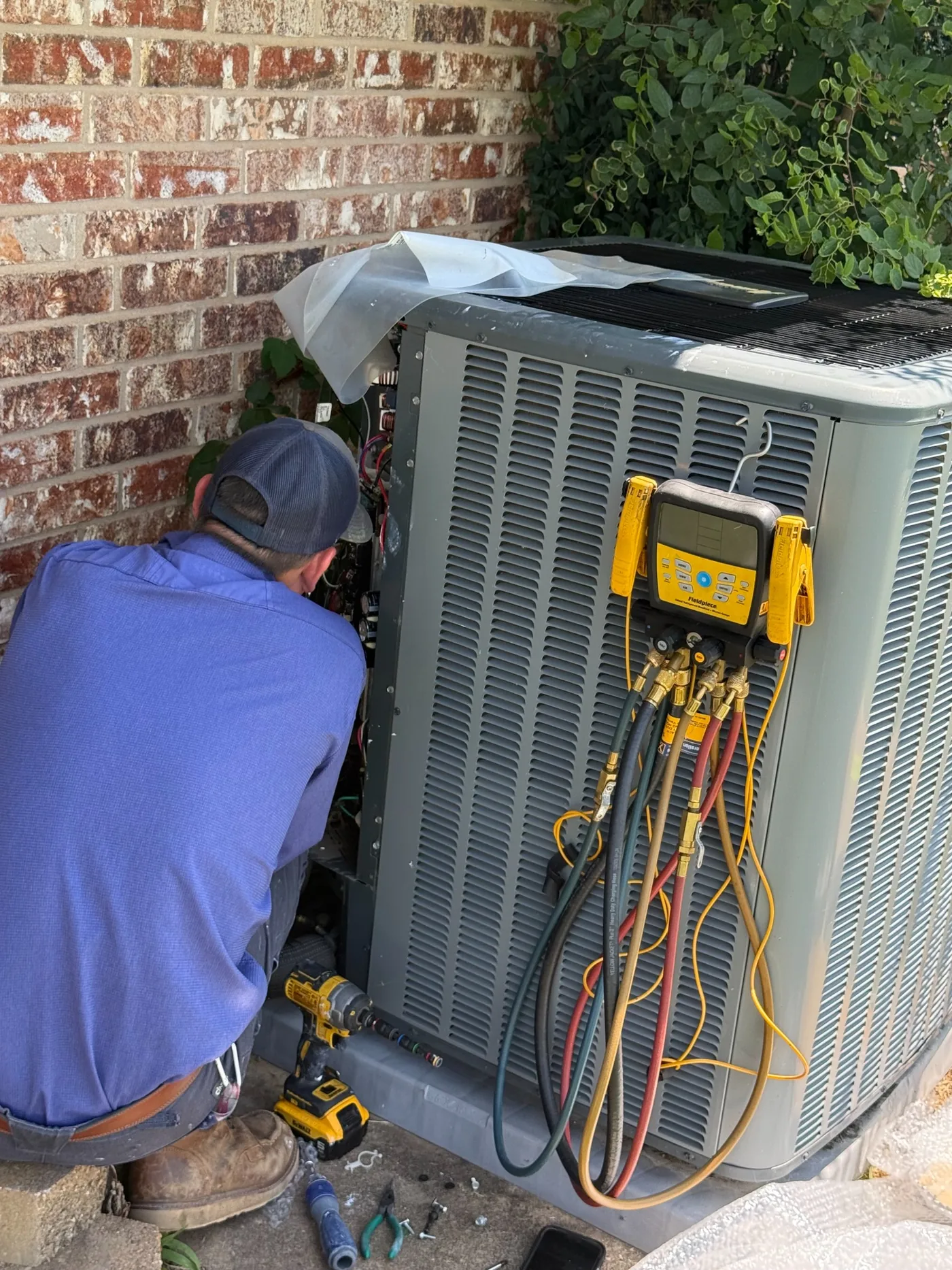 An Advanced Cooling technician checking an outdoor system with service gauges