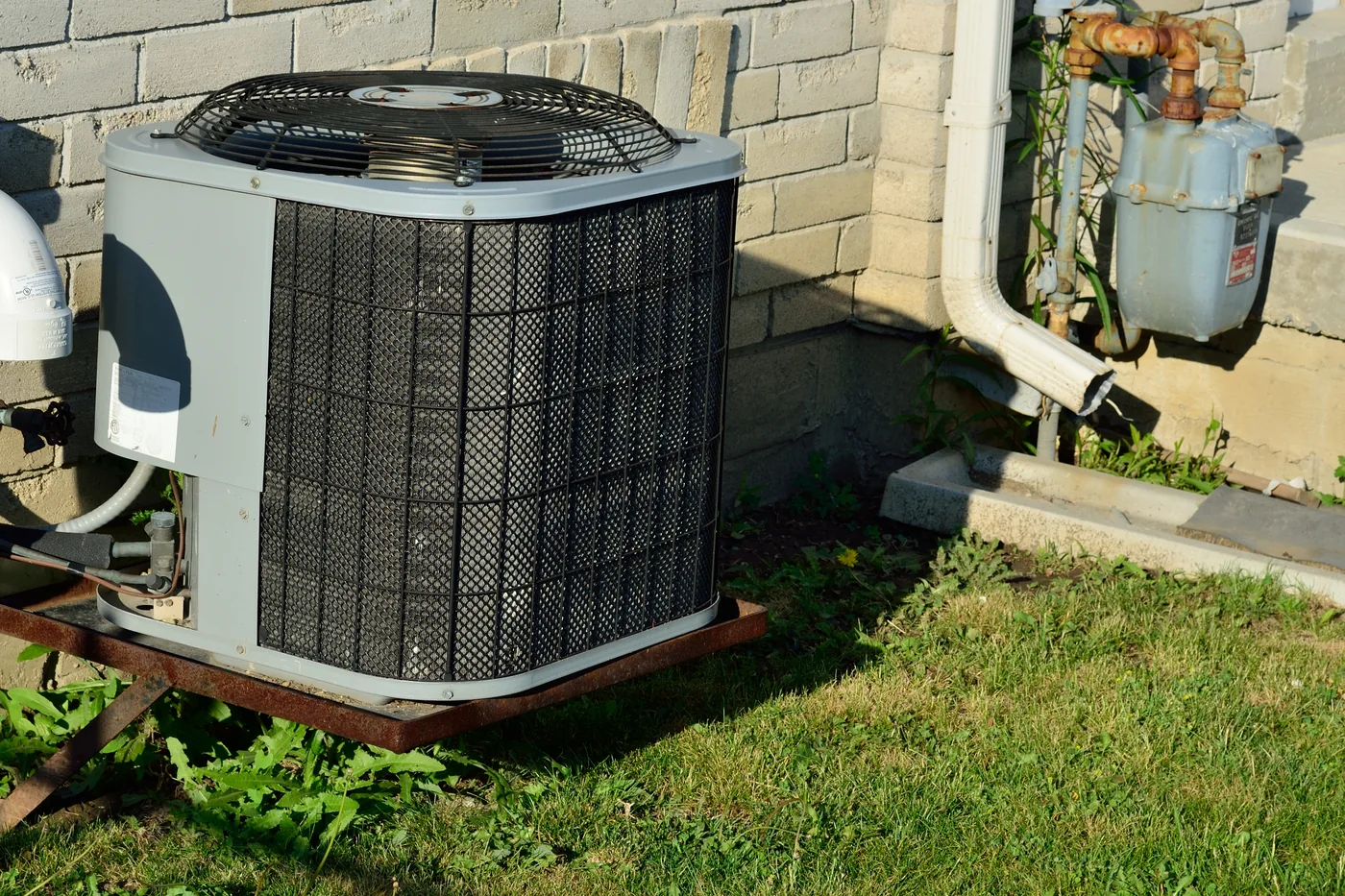An outdoor central air conditioning unit with a top-mounted fan